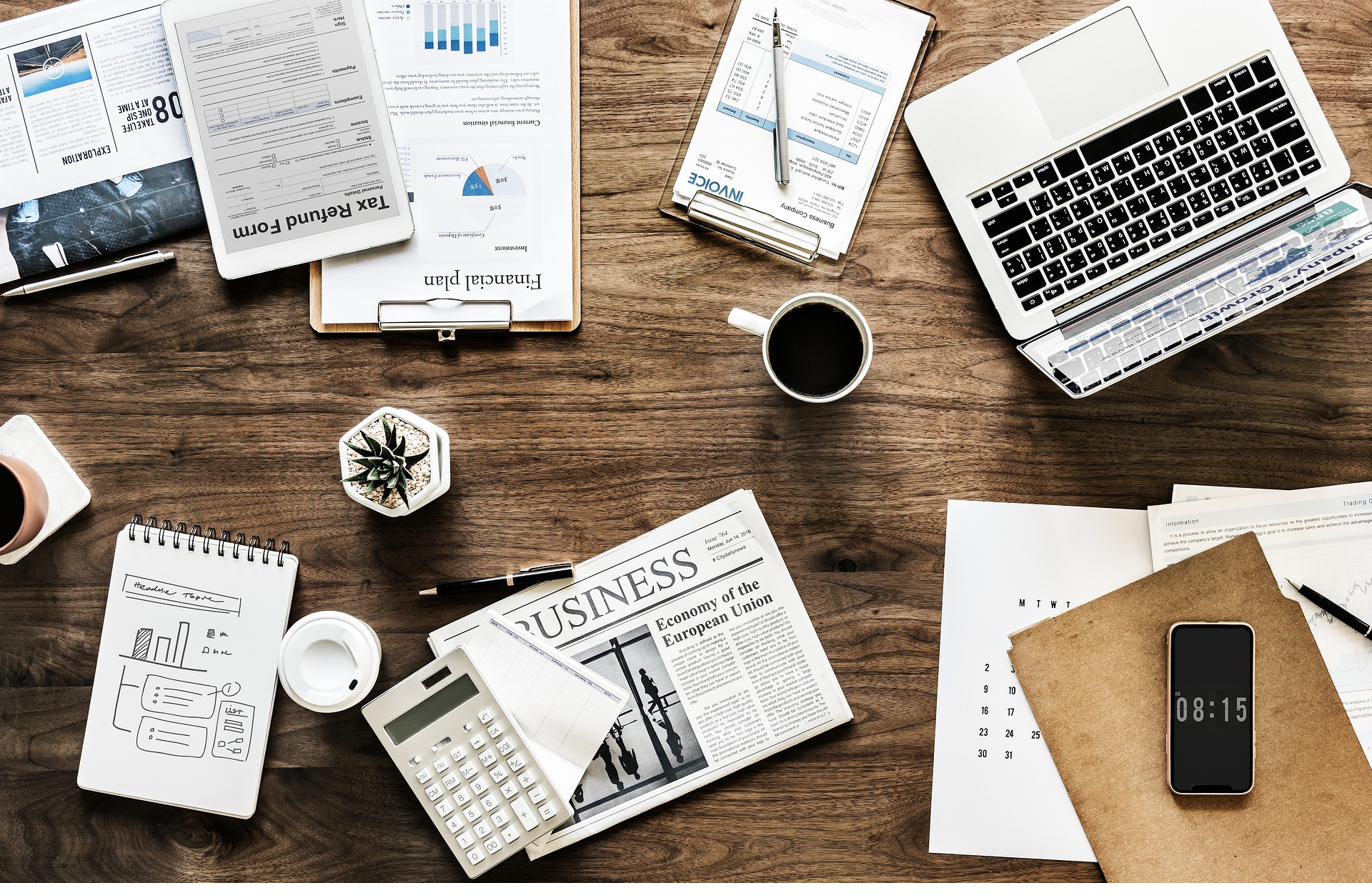 Desk with financial planning documents, laptop, and coffee